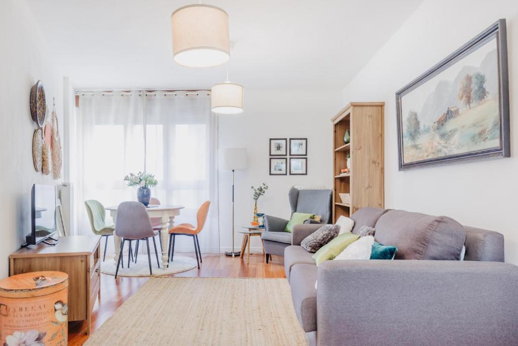 - un salon avec un canapé et une table dans l'établissement Apartamento céntrico con parking y wifi gratis, à Oviedo