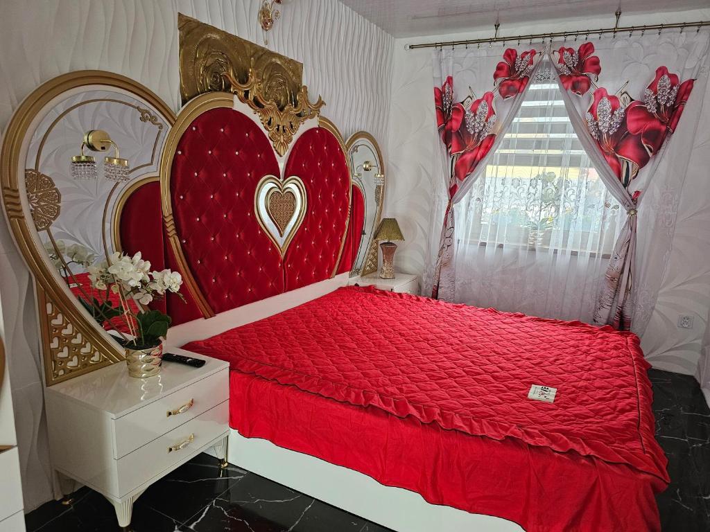 a bedroom with a red bed with a heart headboard at Dom Aurelia in Świnoujście
