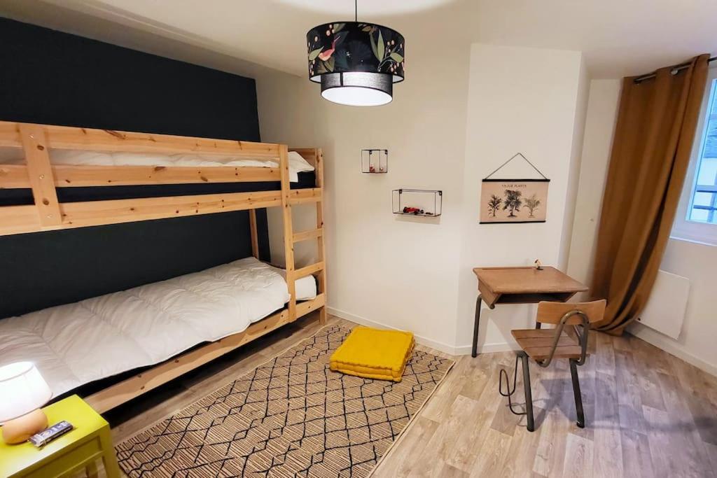 - une chambre avec des lits superposés, un bureau et une table dans l'établissement Home Antonin & Maye, à Tonnerre