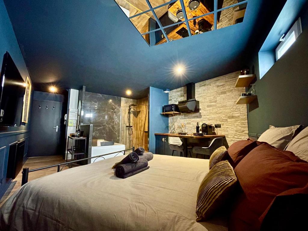 a bedroom with a large bed with a blue ceiling at Sleep'In Cities Le Saphir Balnéo in Albi