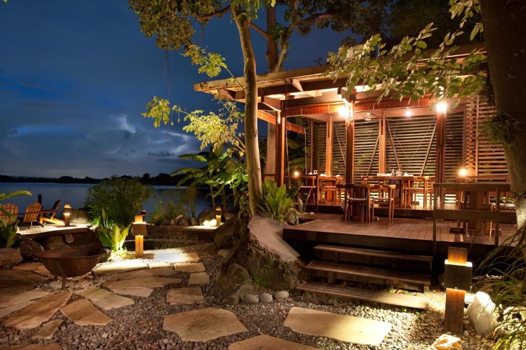 een resort met een tafel en stoelen in de nacht bij Jicaro Island Lodge Member of the Cayuga Collection in Isletas de Granada