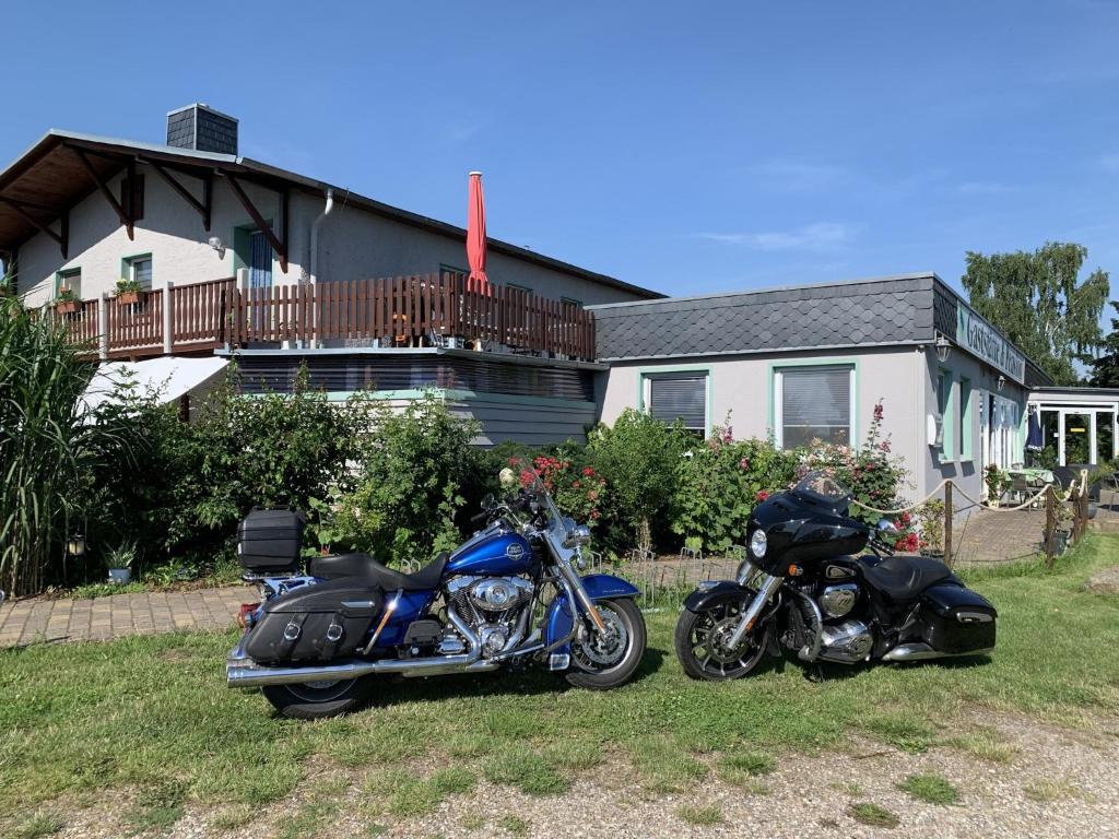 two motorcycles parked in the grass in front of a house at Pension Müritzblick in Gotthun