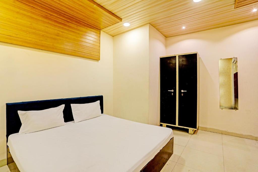 una camera con un letto bianco e una porta nera di OYO Hotel Rose Valley a Indore