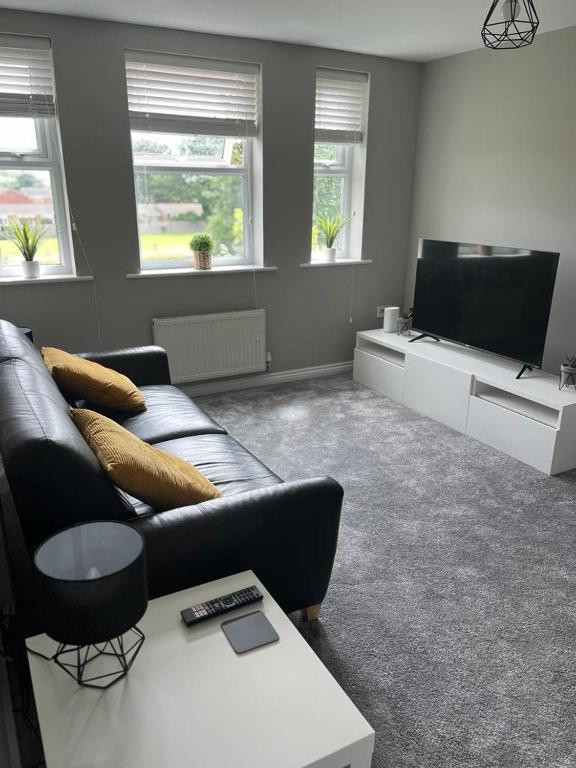 a living room with a couch and a flat screen tv at Thornaby Apartment in Thornaby on Tees