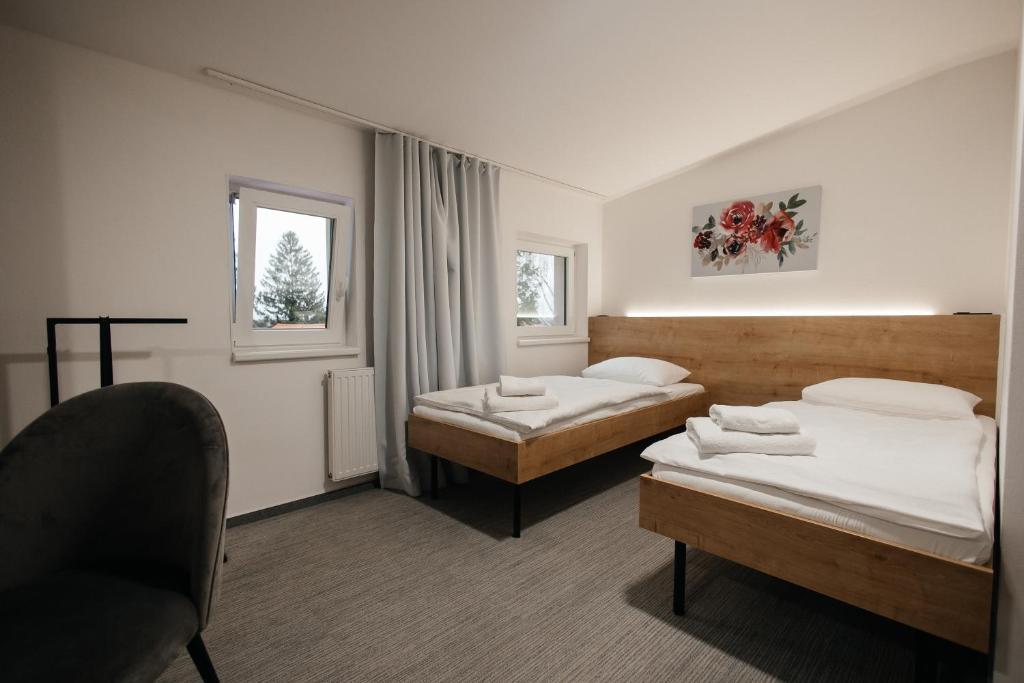 a hotel room with two beds and a chair at Golden Golem hotel & Spa in Prague