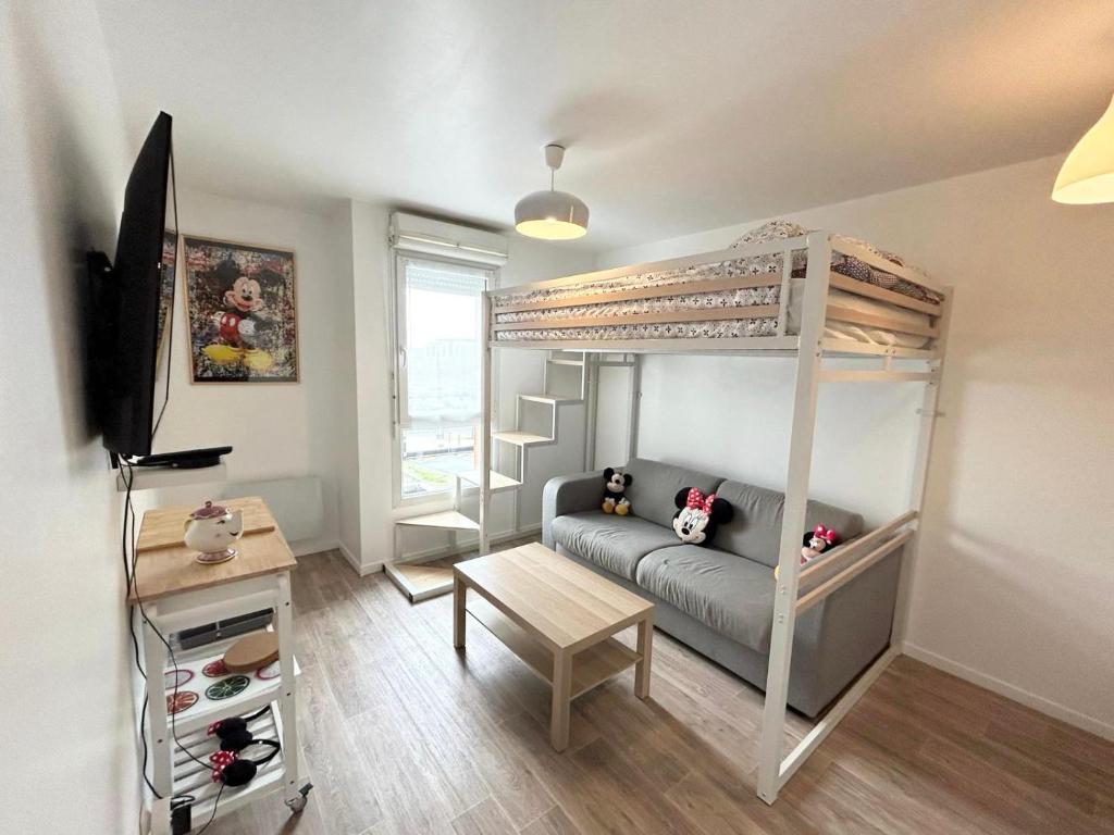 een kleine kamer met een stapelbed en een bank bij Appartement élégant Disneyland in Montévrain