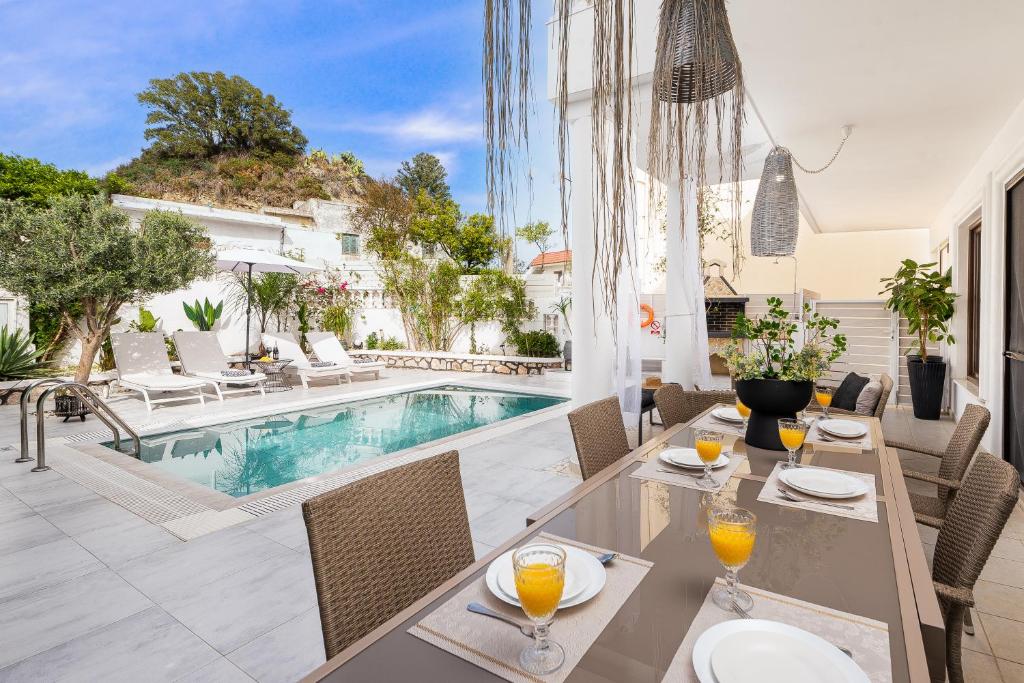 a patio with a table and chairs and a swimming pool at Mikaela's Pool House in Afantou