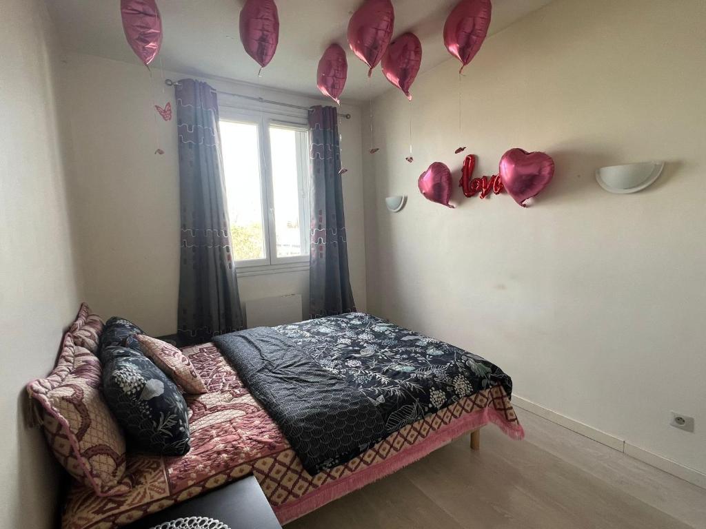 - une chambre dotée d'un lit avec des cœurs sur le mur dans l'établissement sweet room, à Garges-lès-Gonesse