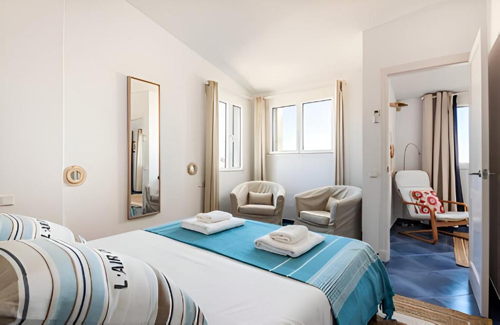 a bedroom with a large bed and two chairs at Villa Roxana in Es Castell