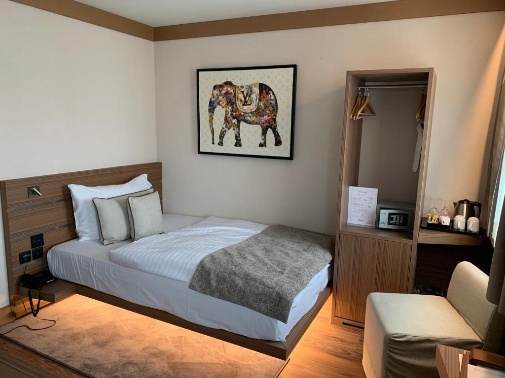 Postel nebo postele na pokoji v ubytování Hôtel Rallye & Entrées aux Bains de la Gruyère