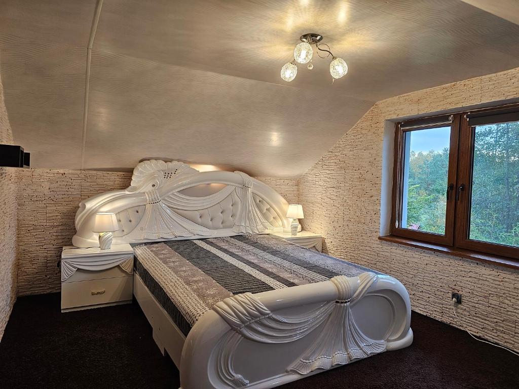 a bedroom with a large white bed and a window at Apartament Aurelia in Świnoujście