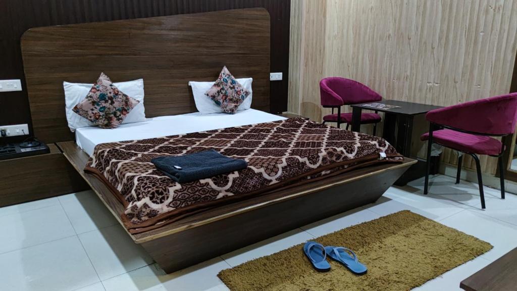 1 dormitorio con 1 cama con sillas moradas y un par de zapatos en Swastik Vatika, en Ambāla