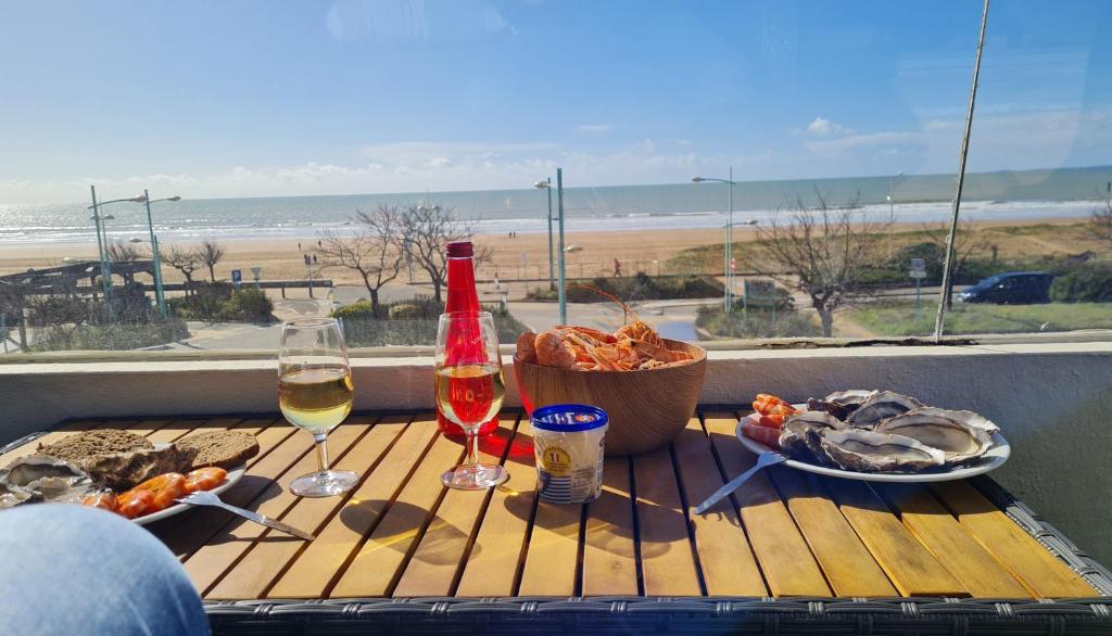 une table avec deux verres de vin et un panier de nourriture dans l'établissement Plein Soleil, à Saint-Jean-de-Monts