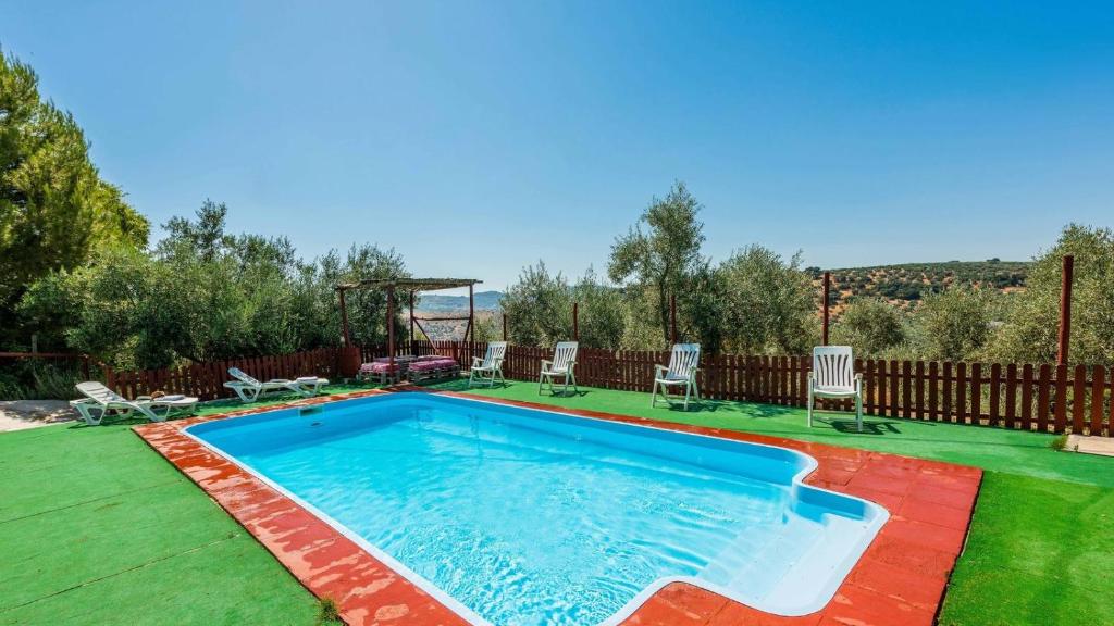 a swimming pool with chairs and a gazebo at Molino Los Justos - Casa Vieja- Algarinejo by Ruralidays in Algarinejo