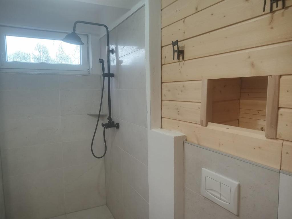 bagno con doccia e parete in legno di Grotini 