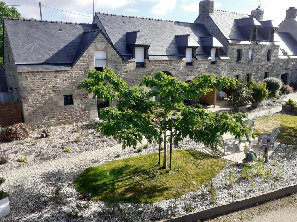 una casa con un árbol delante de ella en Les Gites de Kerdurod, en Guidel