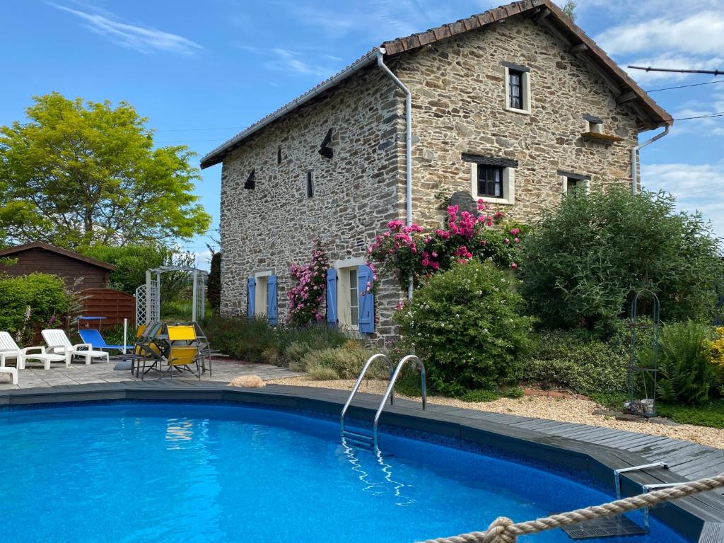 a house with a swimming pool in front of a building at Tardoire cottage in Oradour-sur-Vayres