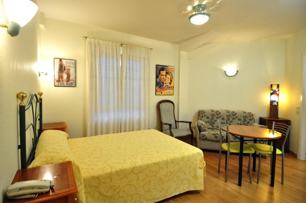 ラ・ラストリージャにあるHotel Apartamentos Aralso Sotilloのベッドルーム1室(ベッド1台、テーブル、椅子付)