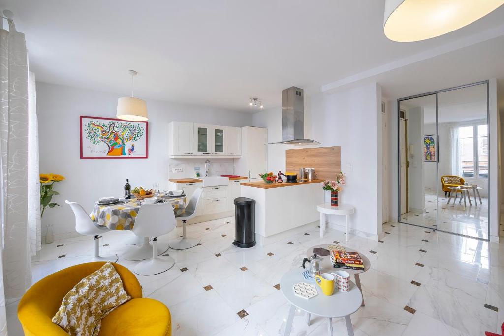una cucina e un soggiorno con tavolo e sedie di Appartement Picasso - Vieil Antibes - Happy Rentals a Antibes