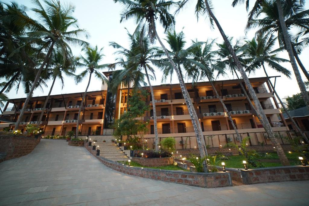 Dharmastala的住宿－Aananda Wellness and Resorts，一座棕榈树建筑