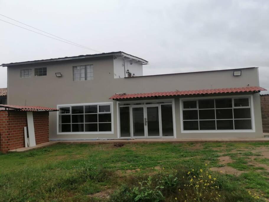Biały dom z dużymi oknami i dziedzińcem w obiekcie Alojamiento en Jauja - Céntrico w Jauja