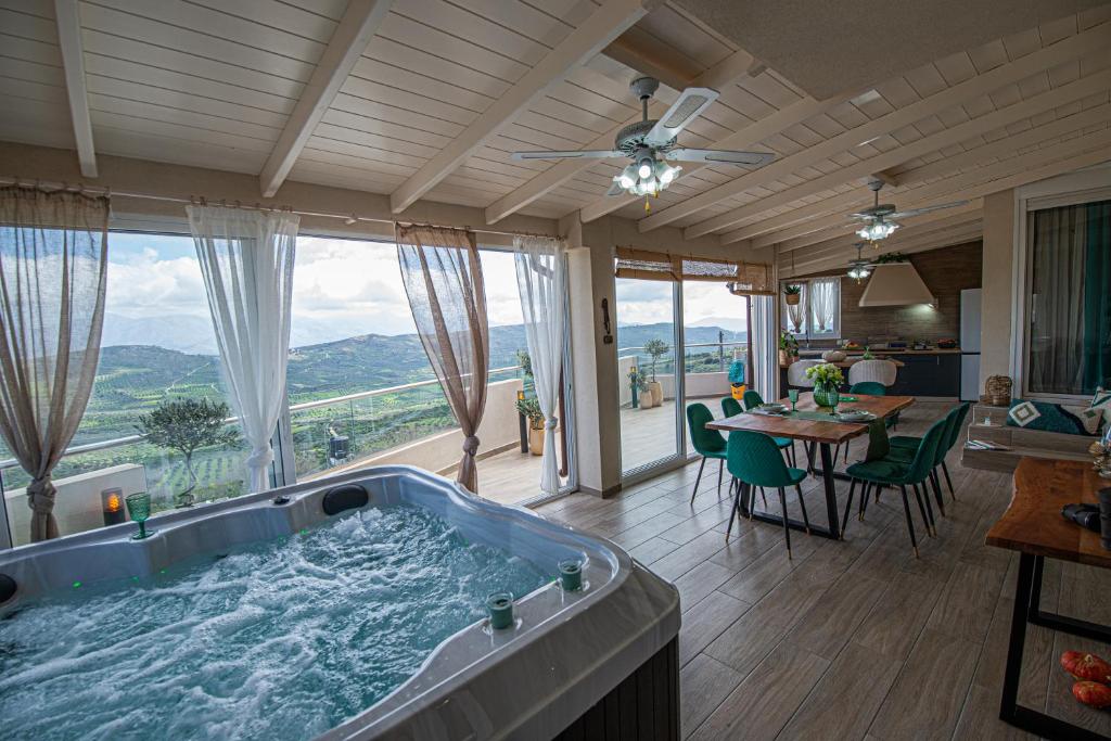 a jacuzzi tub in a living room with a dining table at Nikola's endless view in Stíronas