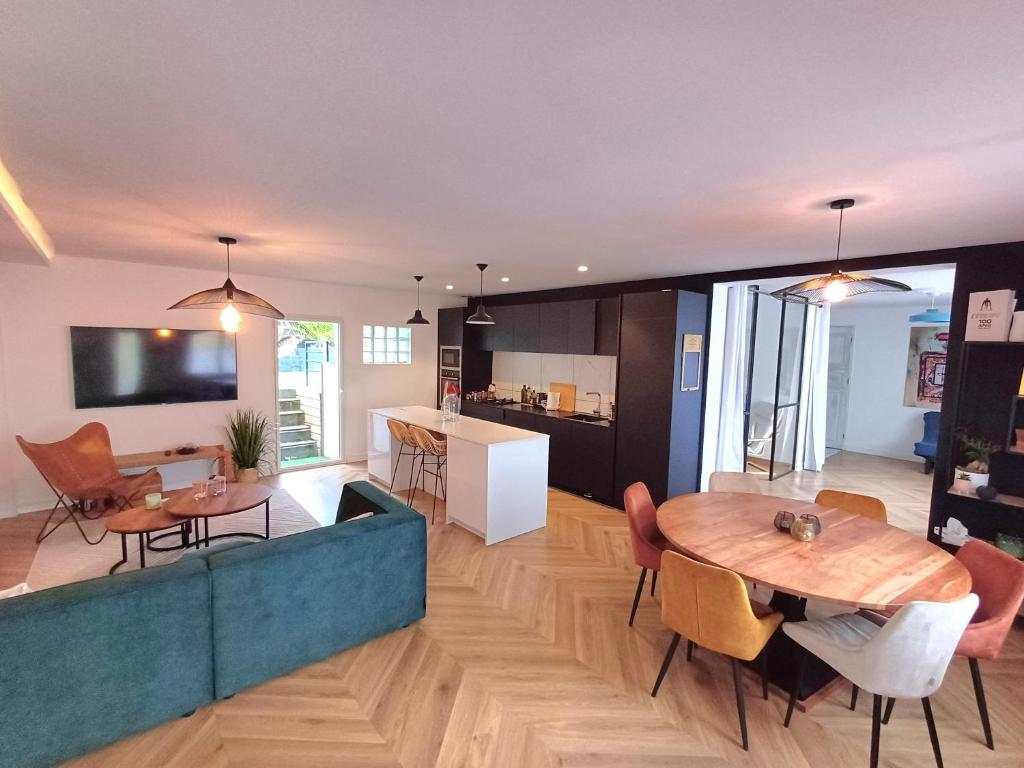 Ranndi Terras - Yourhosthelper conciergerie في لانستير: غرفة معيشة ومطبخ مع طاولة وكراسي