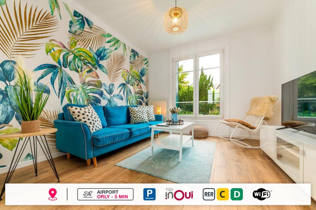 - un salon avec un canapé bleu et un papier peint tropical dans l'établissement Lovely House - Near Paris and Orly Airport, à Juvisy-sur-Orge