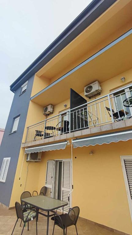 a building with a table and a balcony at Apartments New Charming in Senj