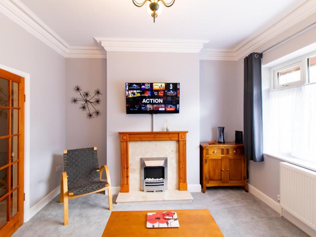 a living room with a fireplace and a tv at Pass the Keys Church View in Ferryhill