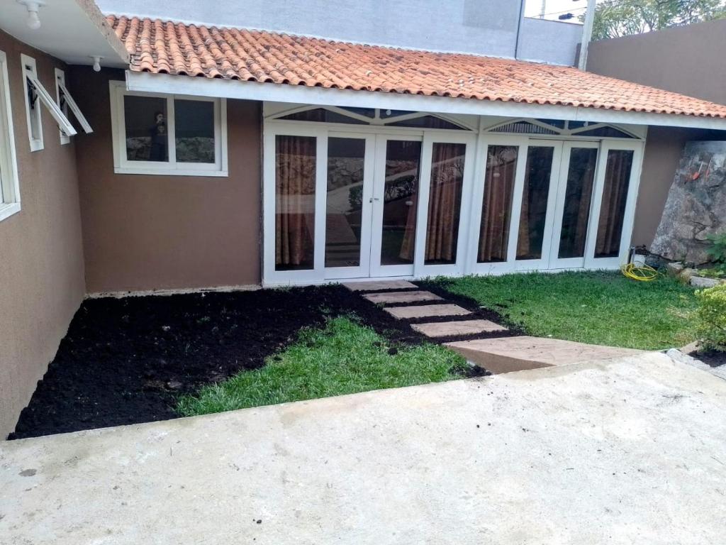 una casa con un porche cubierto y un camino de entrada en Casa 2km do Hospital Angelina Caron e a 15min de Curitiba en Campina Grande do Sul
