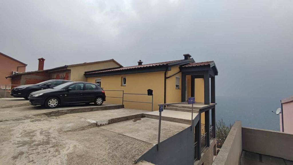 a black car parked in front of a house at Apartments New Charming in Senj