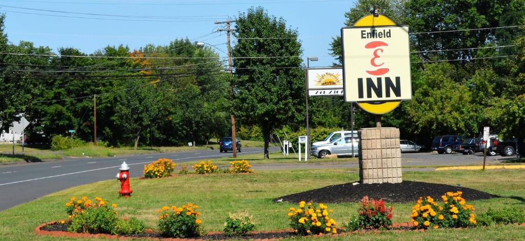 a sign for a hotel and inn with a red fire hydrant at Enfield Inn in Enfield