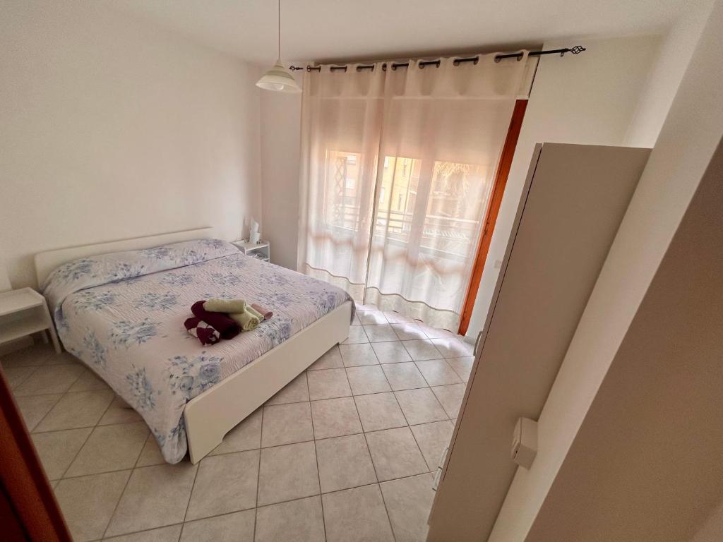 a small bedroom with a bed and a window at Apartment with private parking spot in Oristano's city center in Oristano
