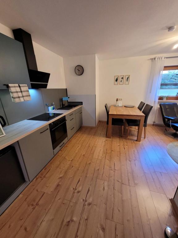 a kitchen with a table and a wooden floor at Fewo - klein aber fein, 1-3 Personen, Souterrain in Rödental