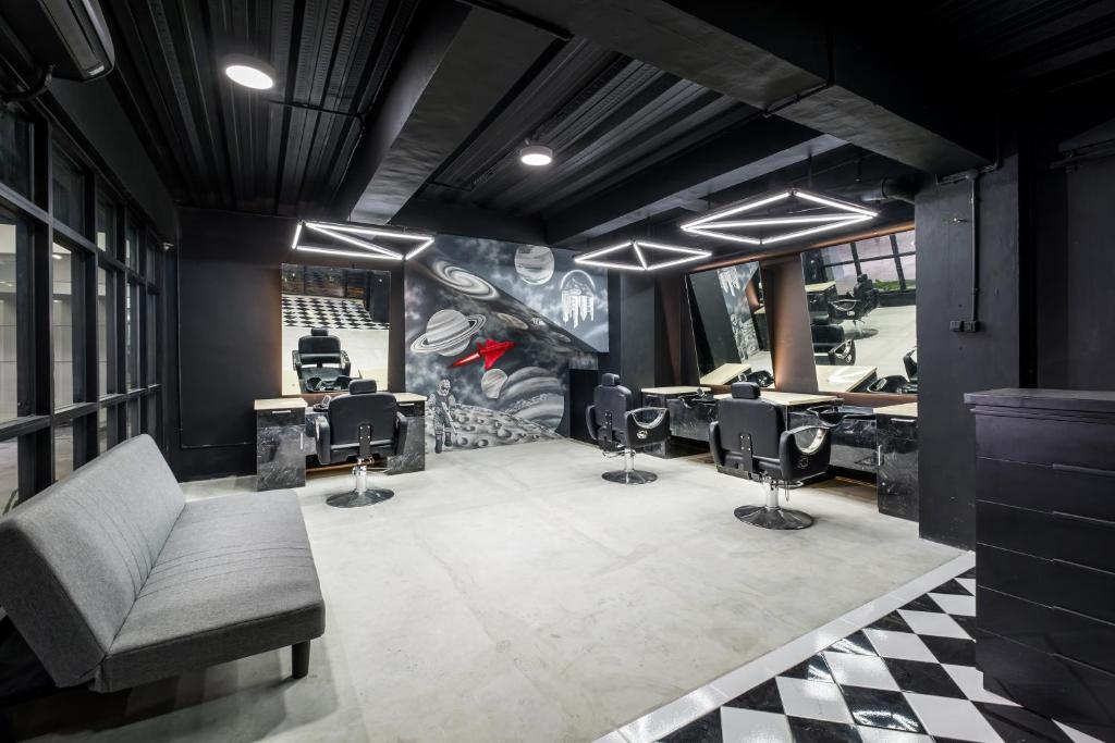 a hair salon with a couch and several barber stations at Gold Hotel Simpang Lima in Semarang