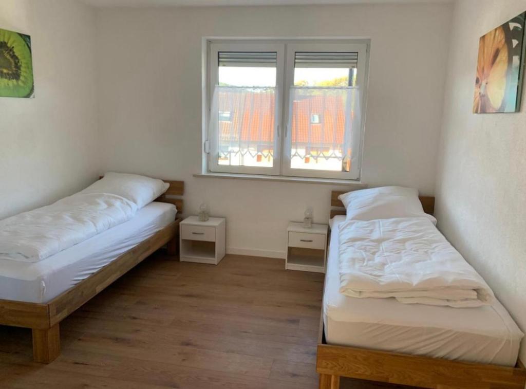 duas camas num quarto com duas janelas em Monteur- und Ferienhaus Weitblick Schonungen em Schonungen