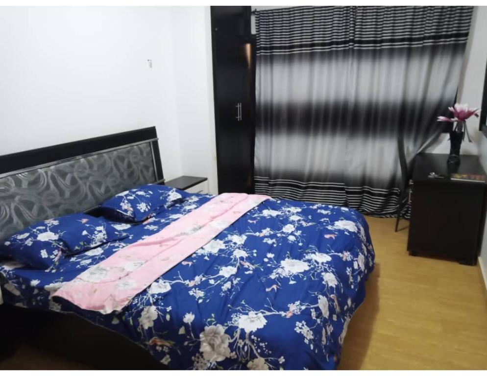una camera con un letto e una coperta blu di Residence Fadi à Diamniadio a Dakar