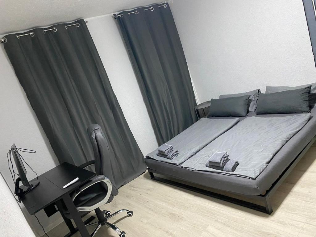 a bedroom with a bed with a desk and a chair at Cozy 2 Rooms Apartment in Bochum