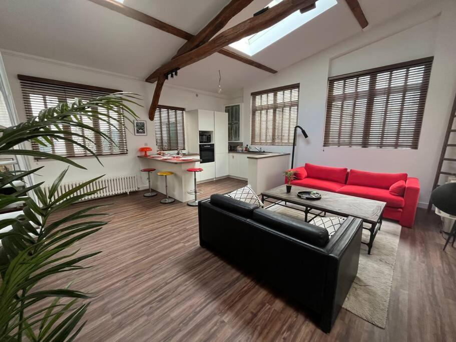 un salon avec un canapé rouge et une cuisine dans l'établissement Magnifique loft avec extérieur, à Paris