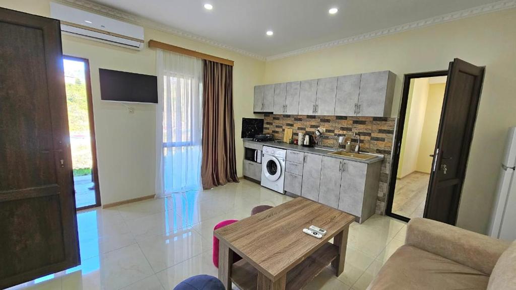a kitchen and living room with a couch and a table at guest hause giorgi,kobuleti- xala in Itʼkhvisi
