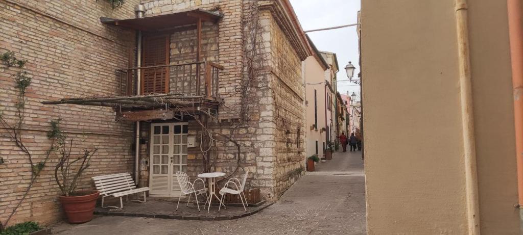 un vicolo con panchina e sedie su un edificio di CASAMIASIROLO - Casa nei vicoli di Sirolo a Sirolo