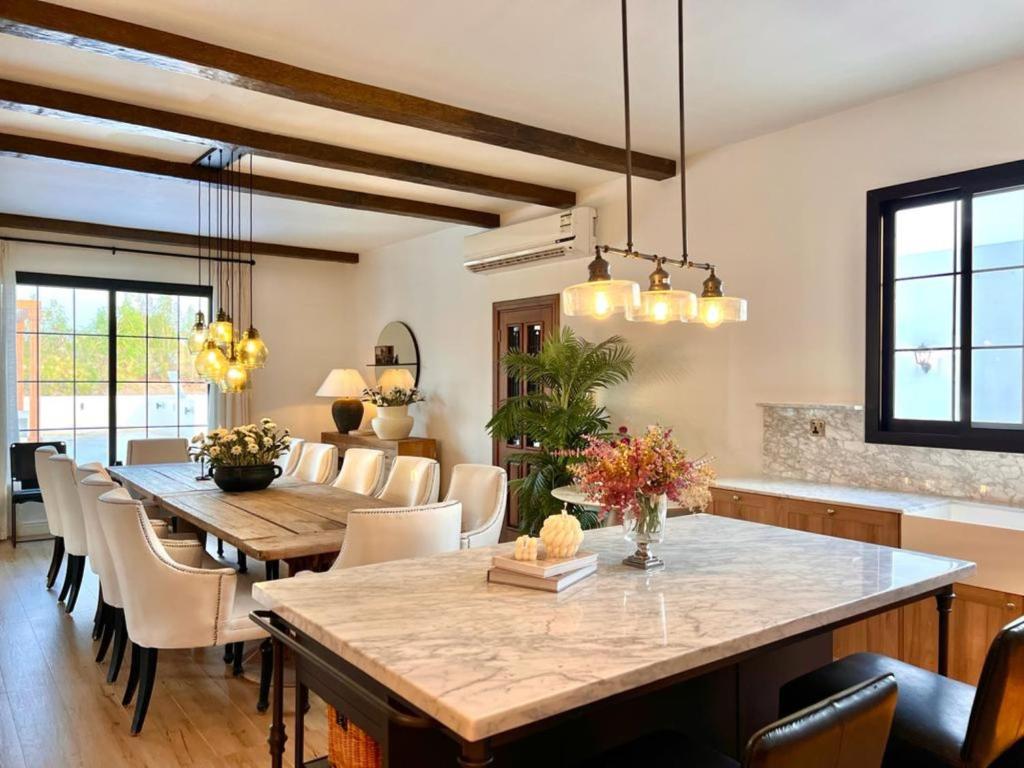 a dining room with a table and chairs at AL JUNAIDI FARM BY BRIDGE RETREATS in Sharjah