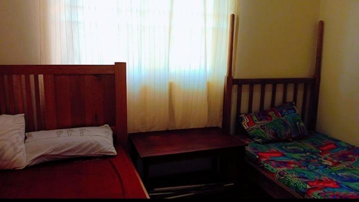 um quarto com 2 camas individuais e uma janela em Sweet Home Buziga em Gaba