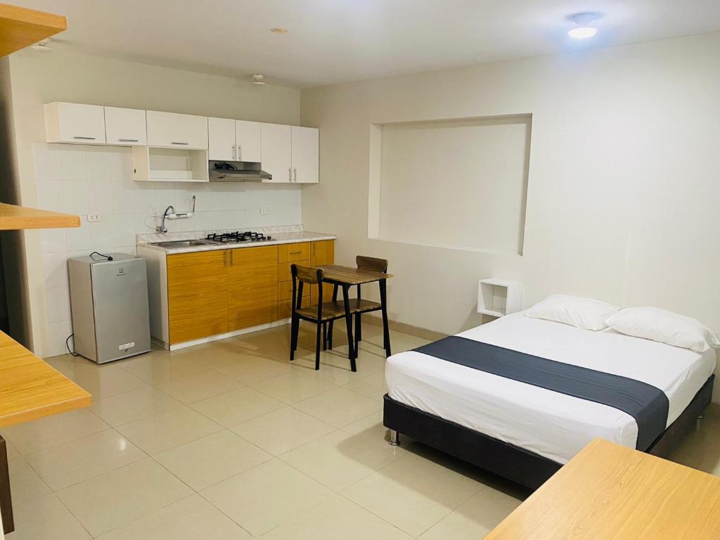 a bedroom with a bed and a small kitchen at Conde Hotel Piura in Piura