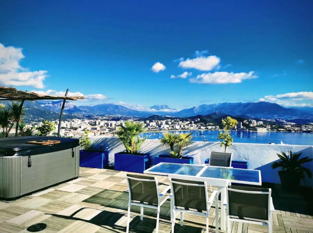 d'une terrasse avec vue sur l'eau et les montagnes. dans l'établissement Penthouse panoramique avec Jacuzzi, à Ajaccio