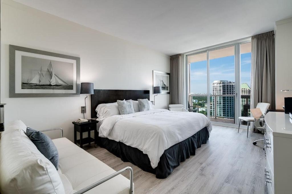 um quarto de hotel com uma cama grande e uma janela em City View Balcony steps from Restaurants, Peacock Park & Marina em Miami