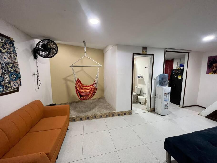 a living room with a couch and a hammock on the wall at Baba’s Beach Bungalow in Providencia