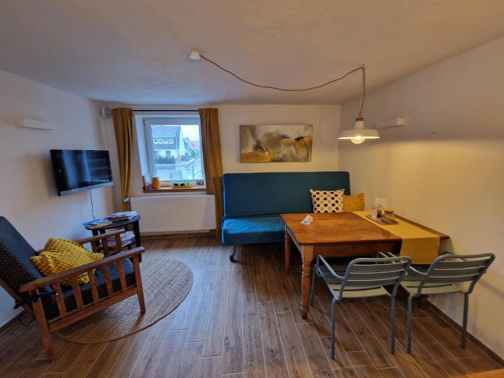 ein Wohnzimmer mit einem blauen Sofa und einem Tisch in der Unterkunft Ferienwohnung by Thomas Extertal in Extertal