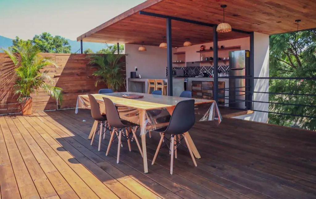 a wooden deck with a table and chairs on it at Casa Oaxaca in Oaxaca City